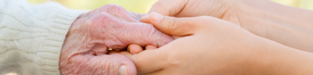 Young person holding elderly person's hand in Seminole, FL