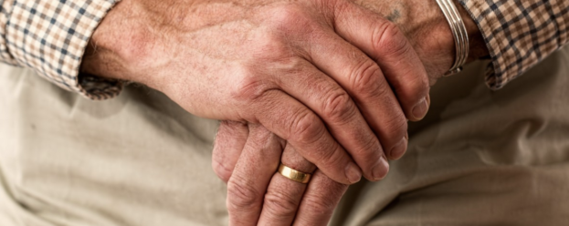 Elderly person with their hands crossed